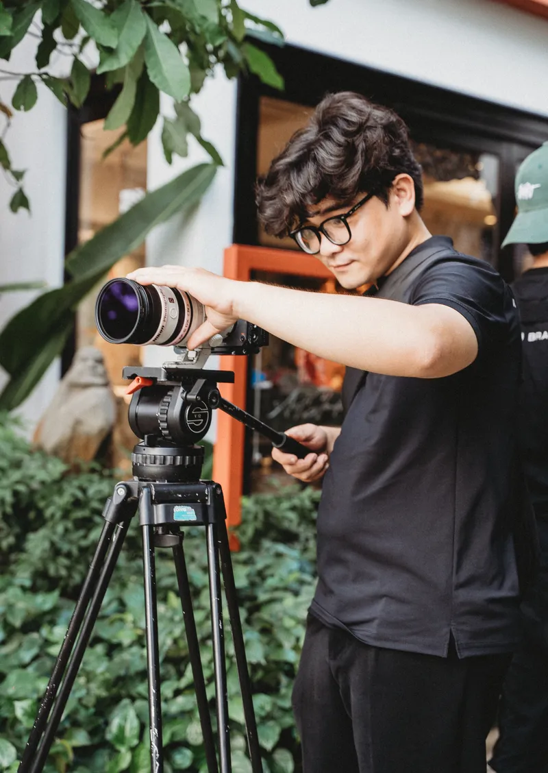 Cinematographer adjusting the camera rig outdoors between takes
