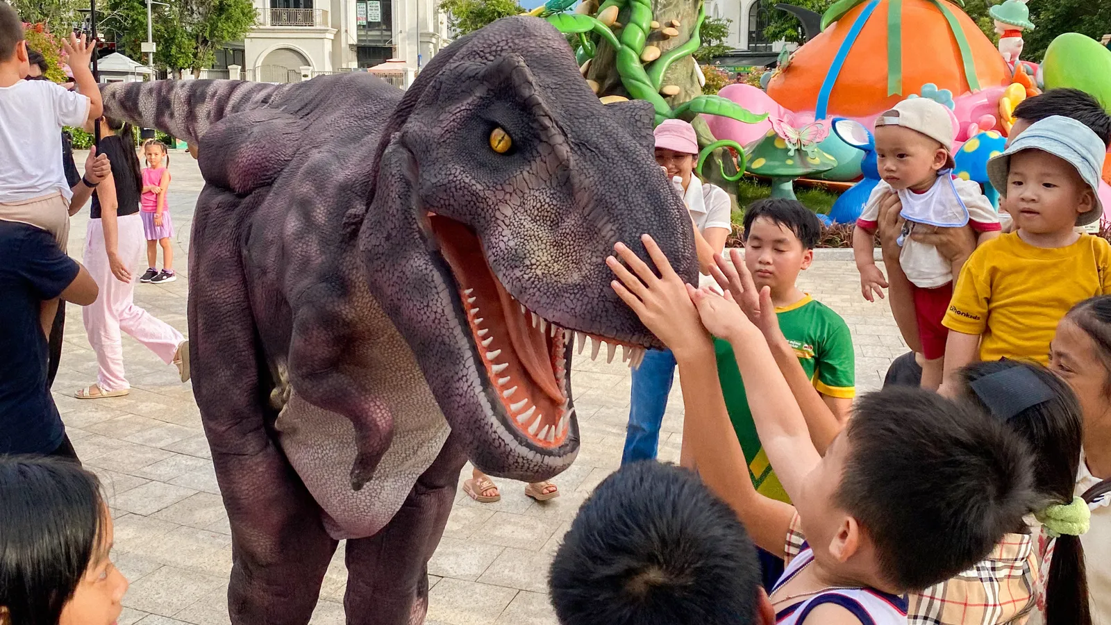Young kids playing alongside the Vegetarian T-rex