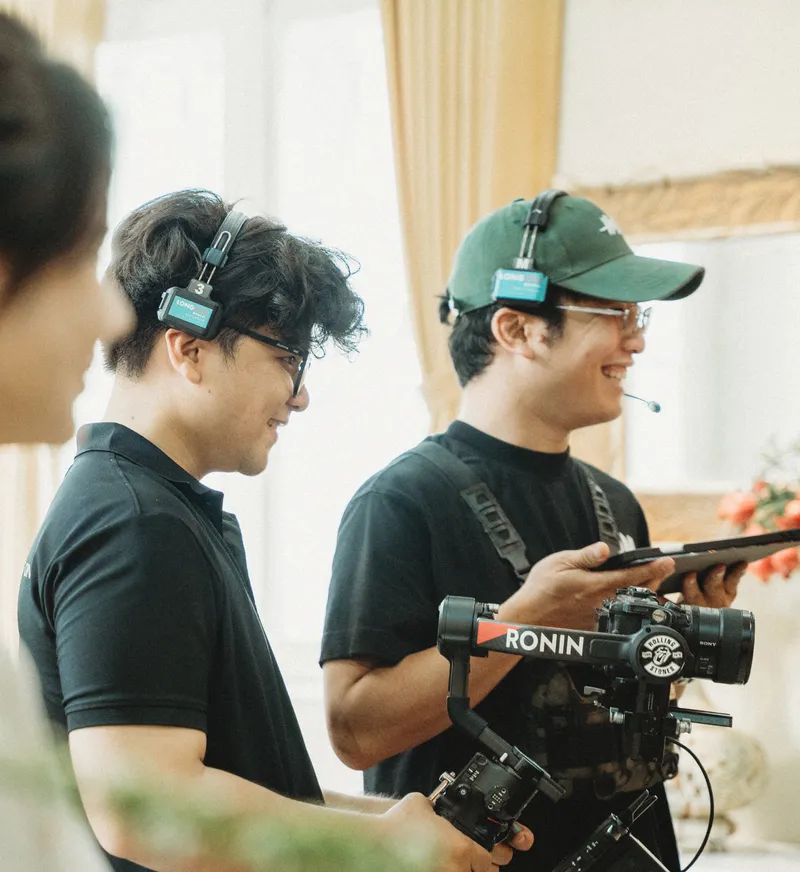 Crew members smiling behind a Ronin gimbal rig on set