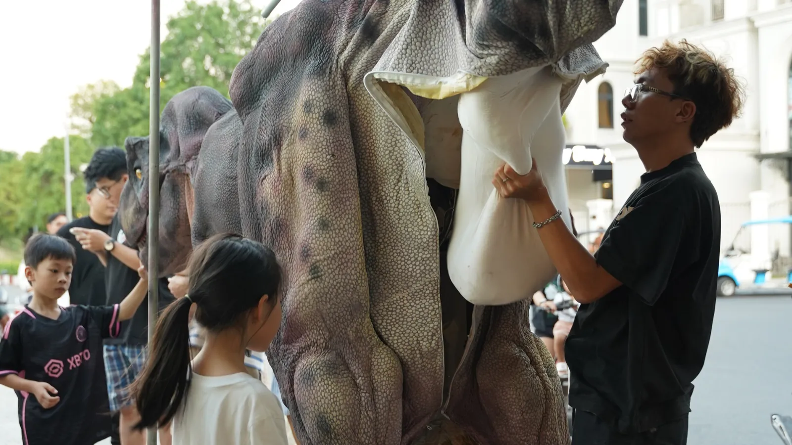 The crew operating the Vegetarian T-rex costume